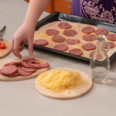 female-hands-lay-out-sausage-on-pizza-dough-do-it-2022-04-30-10-04-50-utc