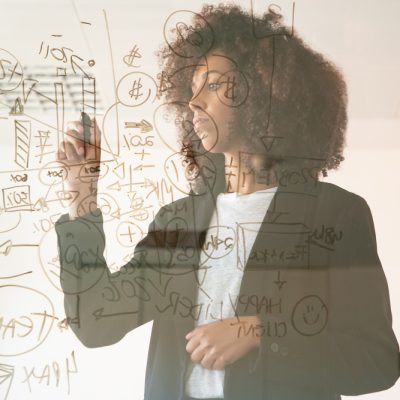focused-young-businesswomen-writing-on-virtual-board-concentrated-young-african-american-female-manager-holding-marker-and-making-noted-on-chart-strategy-busines
